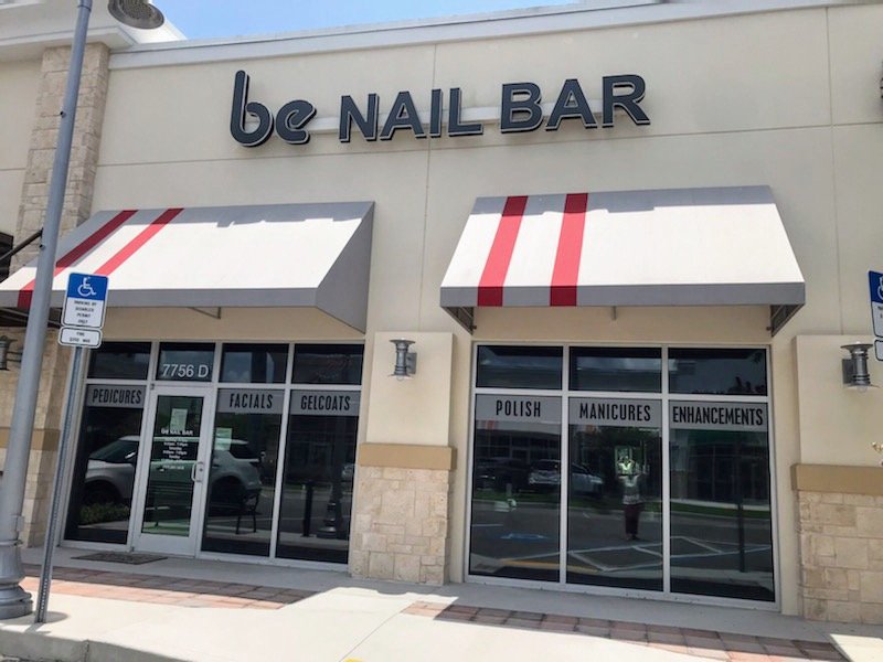 Nail salon stations with polished manicure tools.